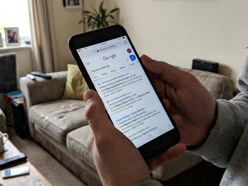 A phone screen showing Google search results for bouncy castle hire near me