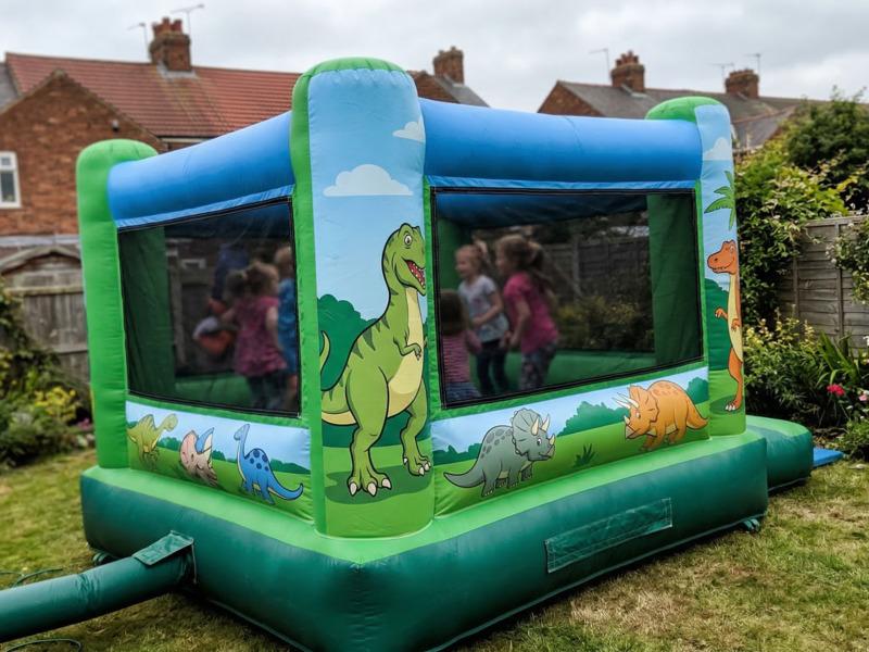 A brightly themed bouncy castle set up in a back garden for a children's birthday party