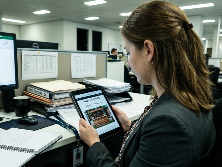 An event planner browsing a mobile bar hire website on a tablet