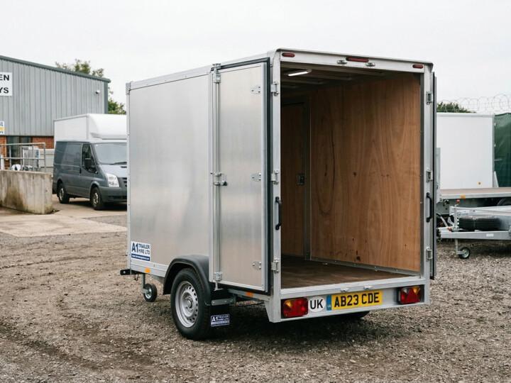 Enclosed box trailer with rear doors open showing clean interior at a trailer hire yard